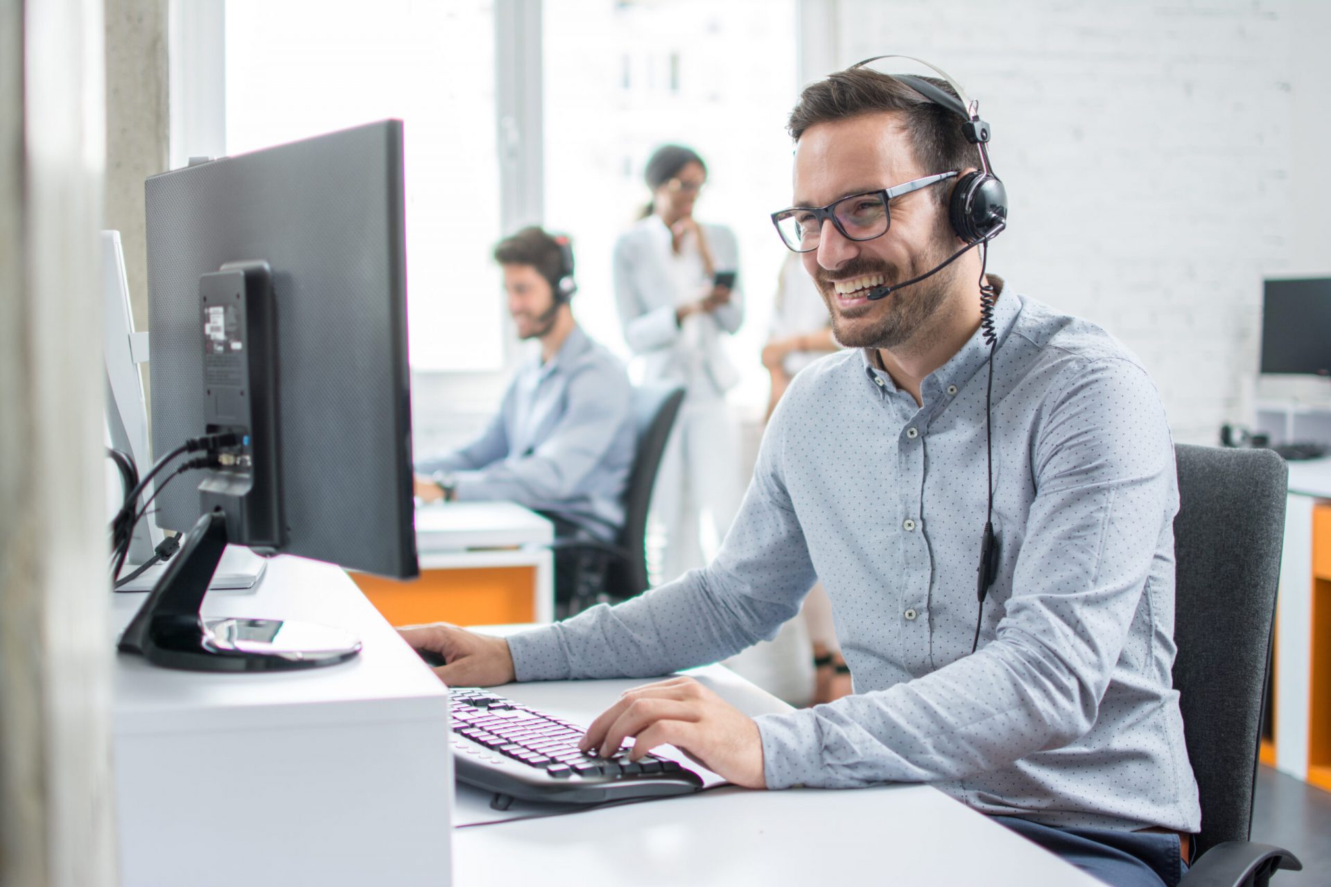 Smiling,Customer,Support,Operator,With,Hands-free,Headset,Working,In,The